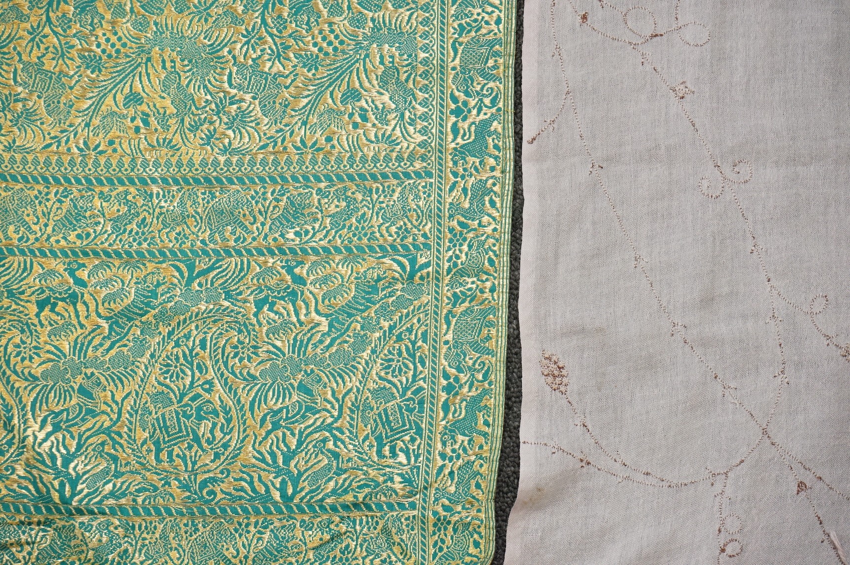 An Indian green and gold silk hand woven brocade stole, a cream pashmina embroidered stole and a similar finely woven and embroidered lilac stole (3). Brocade stole 38cm x 180cm., Condition - light stain to finely woven